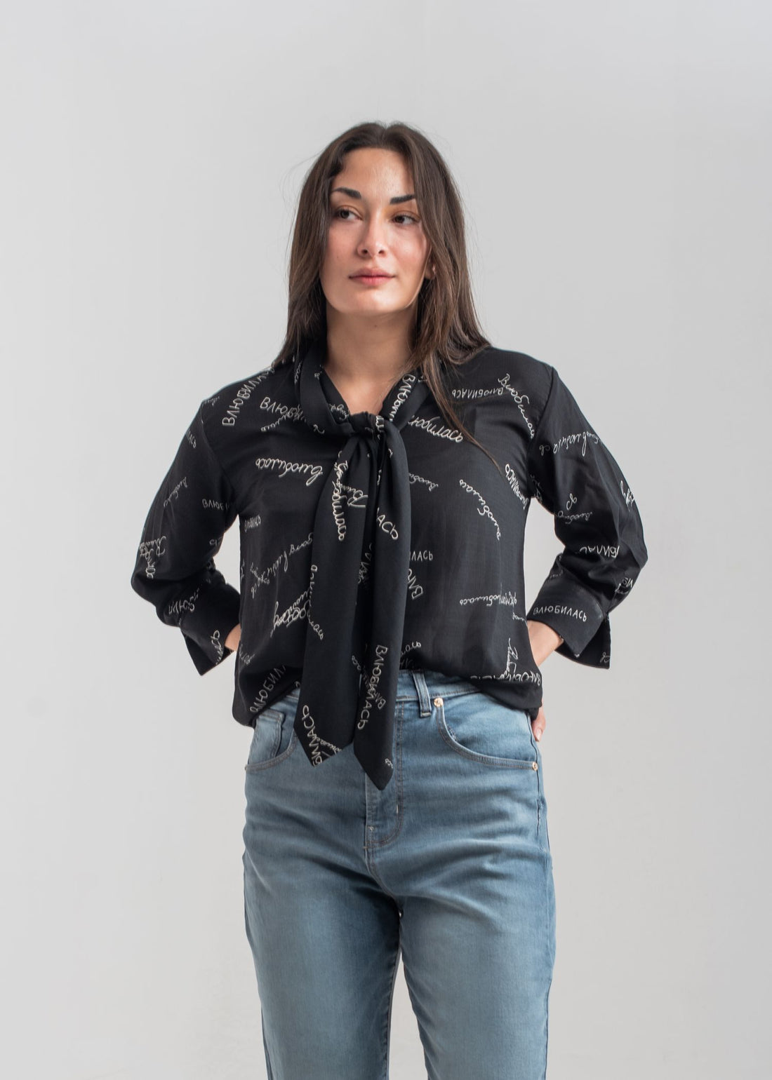 Women's printed bow top in black with a tie neck collar