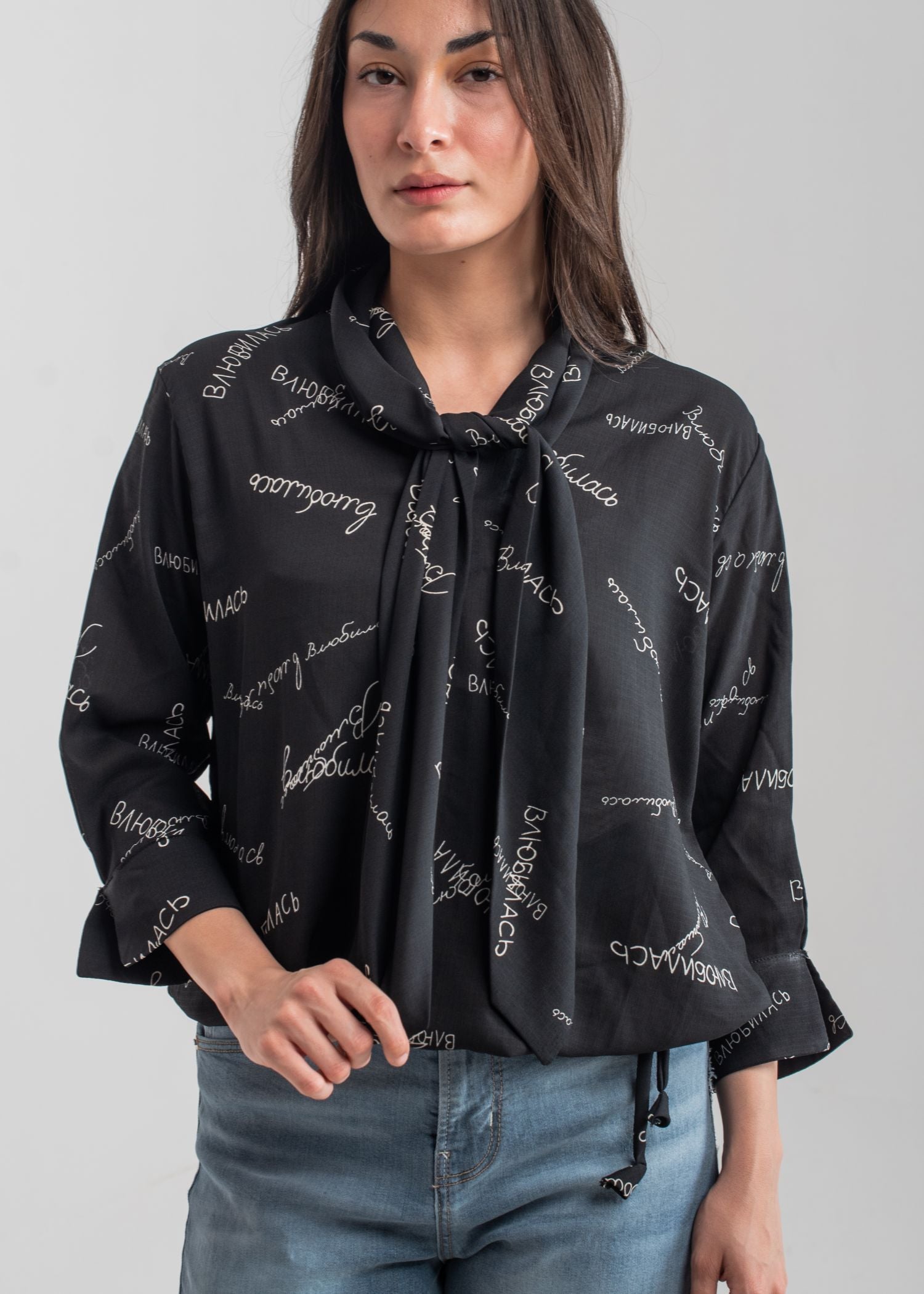 Women's printed bow top in black with a tie neck collar