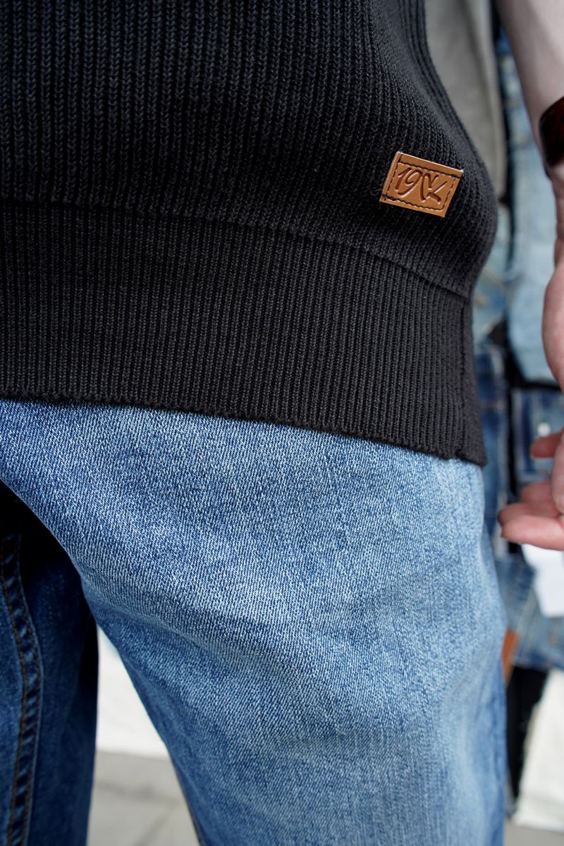 A Close-Up of Men's Black Knitted Short Sleeve Polo Shirt with 1947 Clothing's Logo