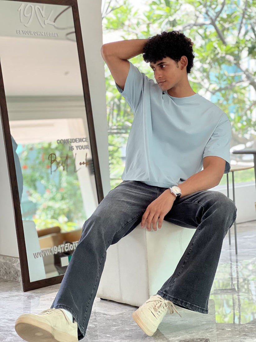 Person Wearing Faded Black Bootcut Jeans by 1947 Clothing