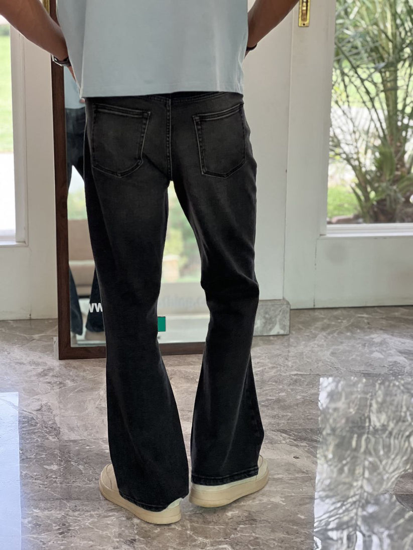 Person Wearing Faded Black Bootcut Jeans by 1947 Clothing