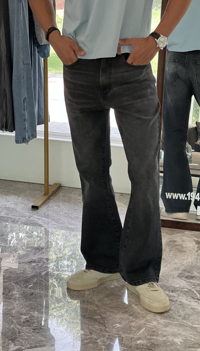 Person Wearing Faded Black Bootcut Jeans by 1947 Clothing