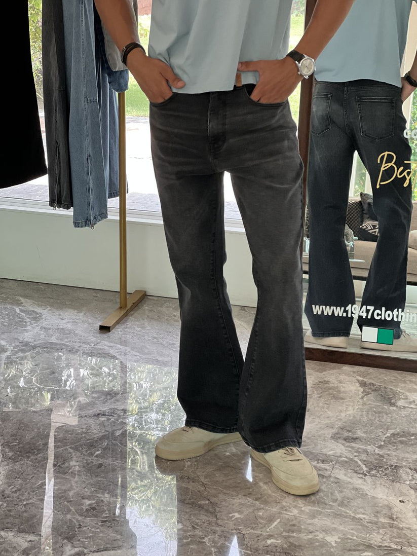 Person Wearing Faded Black Bootcut Jeans by 1947 Clothing