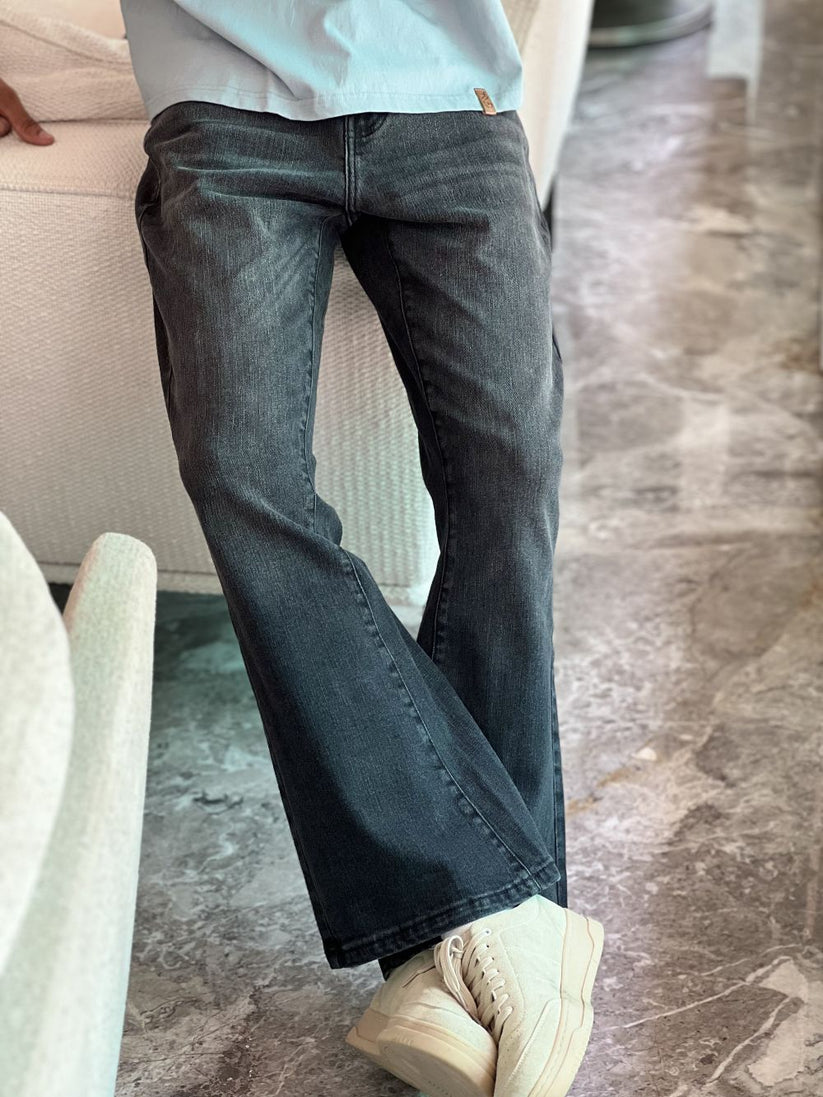 Person Wearing Faded Black Bootcut Jeans by 1947 Clothing