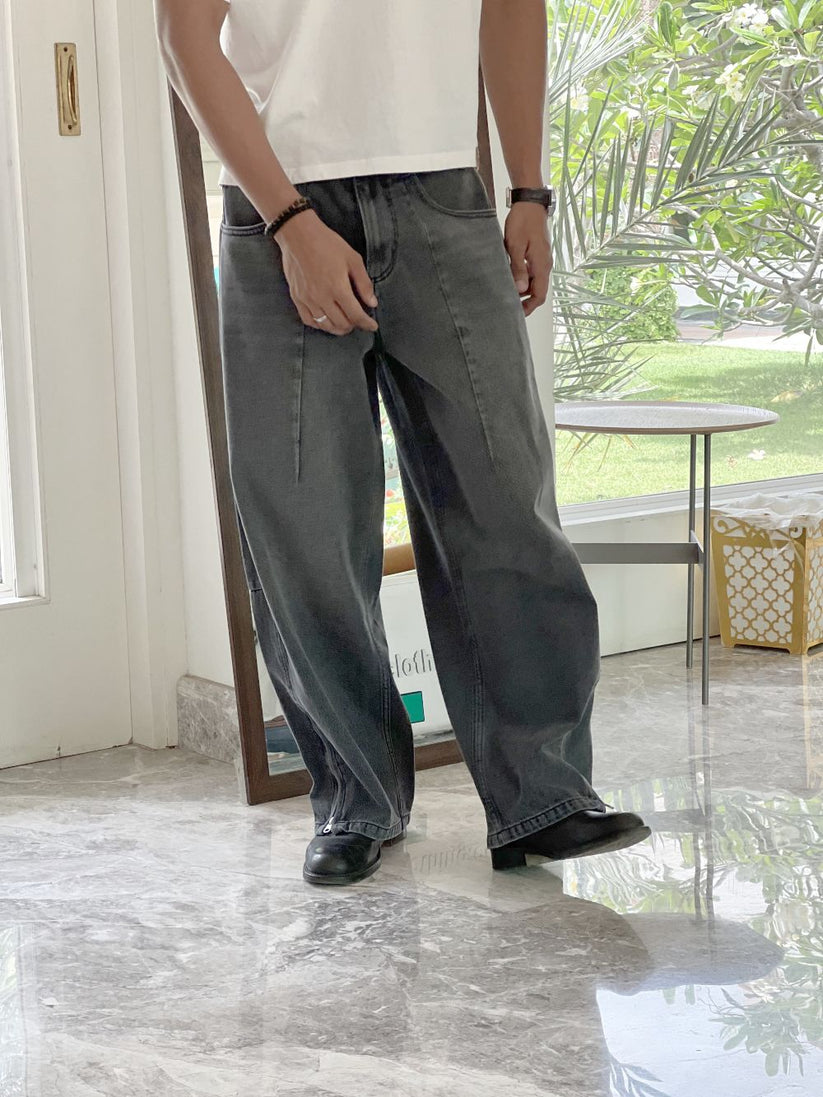 Person wearing gray baggy jeans indoors with a blurred background by 1947 clothing