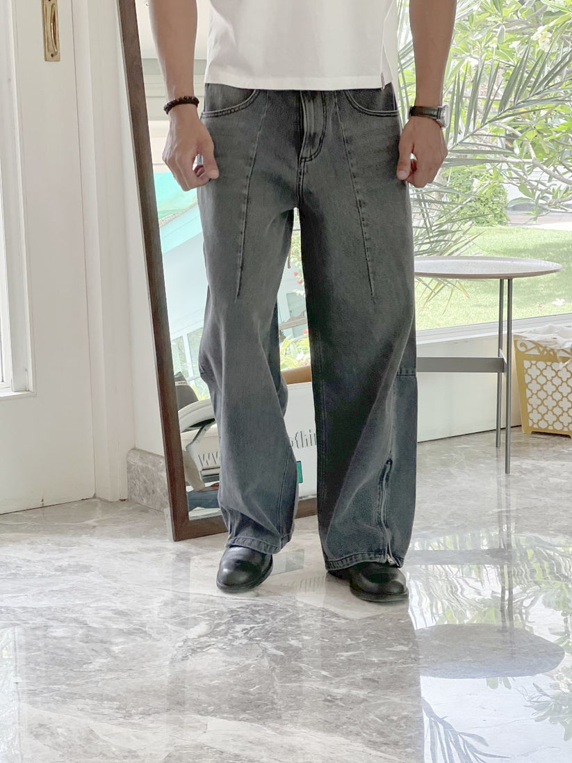 Person wearing gray baggy jeans indoors with a blurred background by 1947 clothing