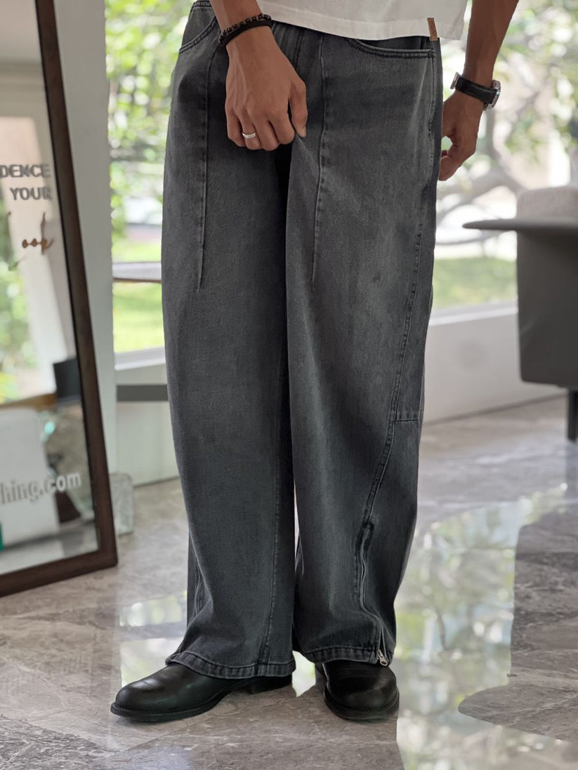 Person wearing gray baggy jeans indoors with a blurred background by 1947 clothing