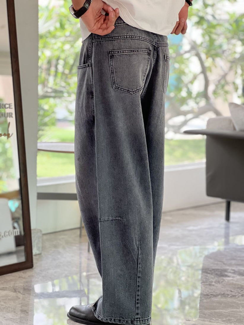 Person wearing gray baggy jeans indoors with a blurred background by 1947 clothing