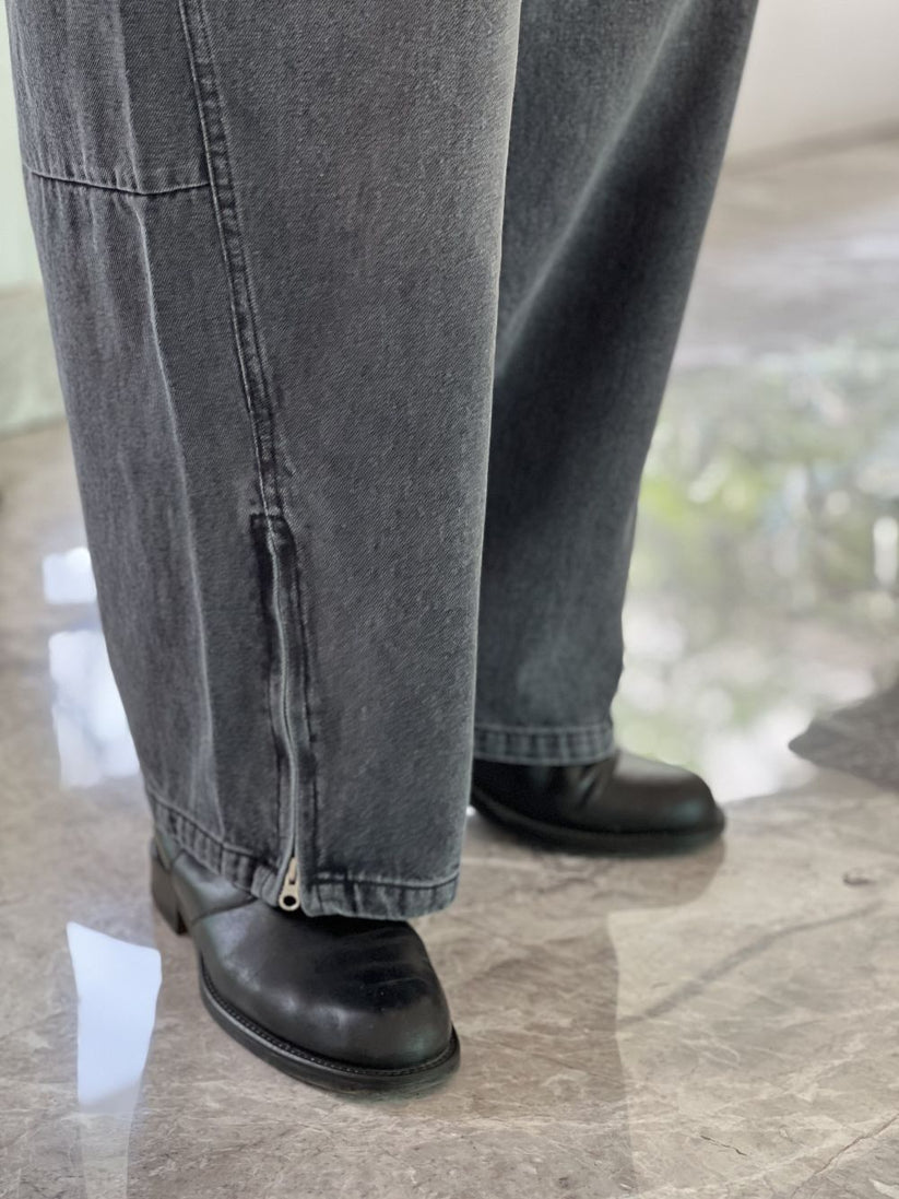Person wearing gray baggy jeans indoors with a blurred background by 1947 clothing