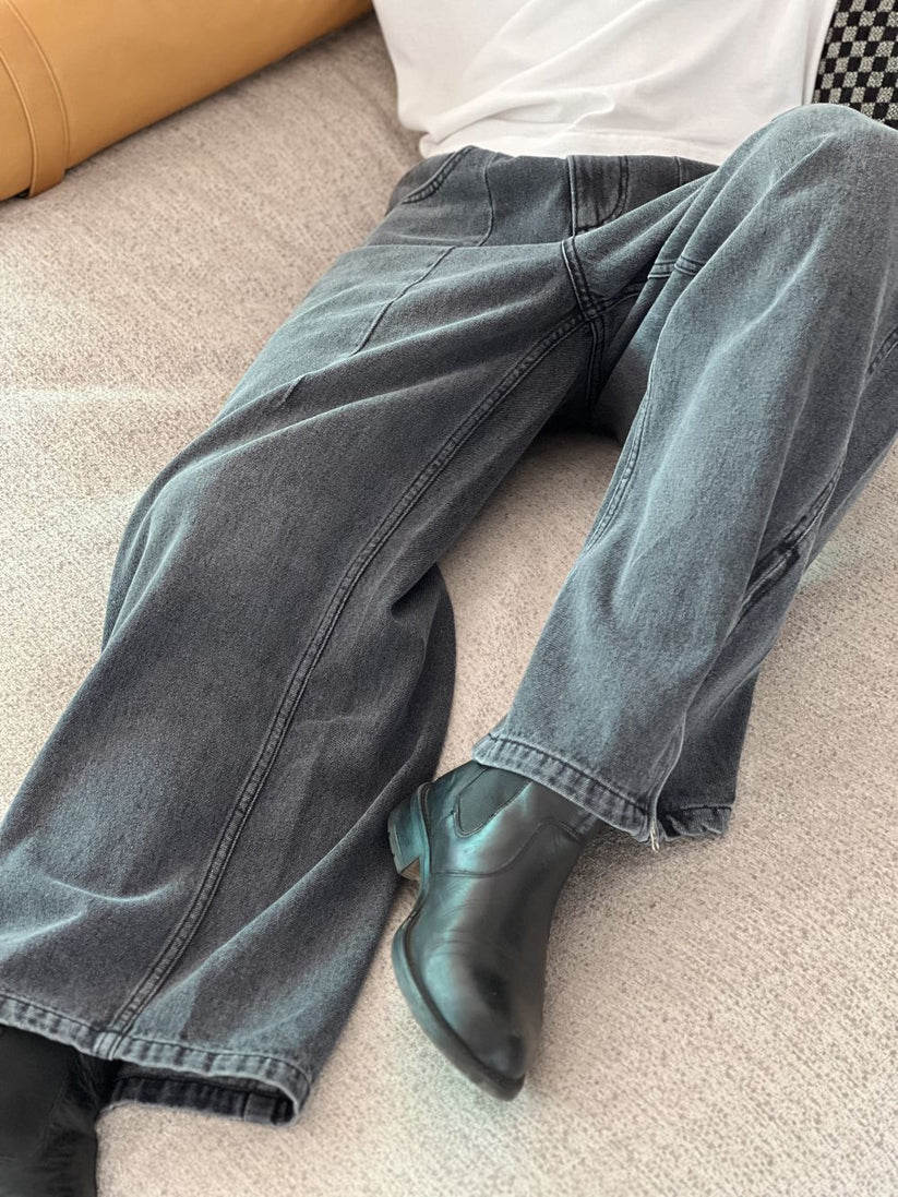 Person wearing gray baggy jeans indoors with a blurred background by 1947 clothing