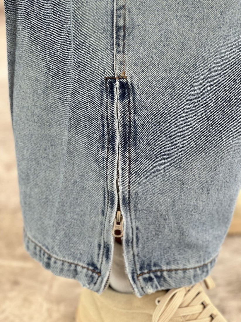 Person wearing light blue baggy jeans with White Boxy Tshirt by 1947 clothing.