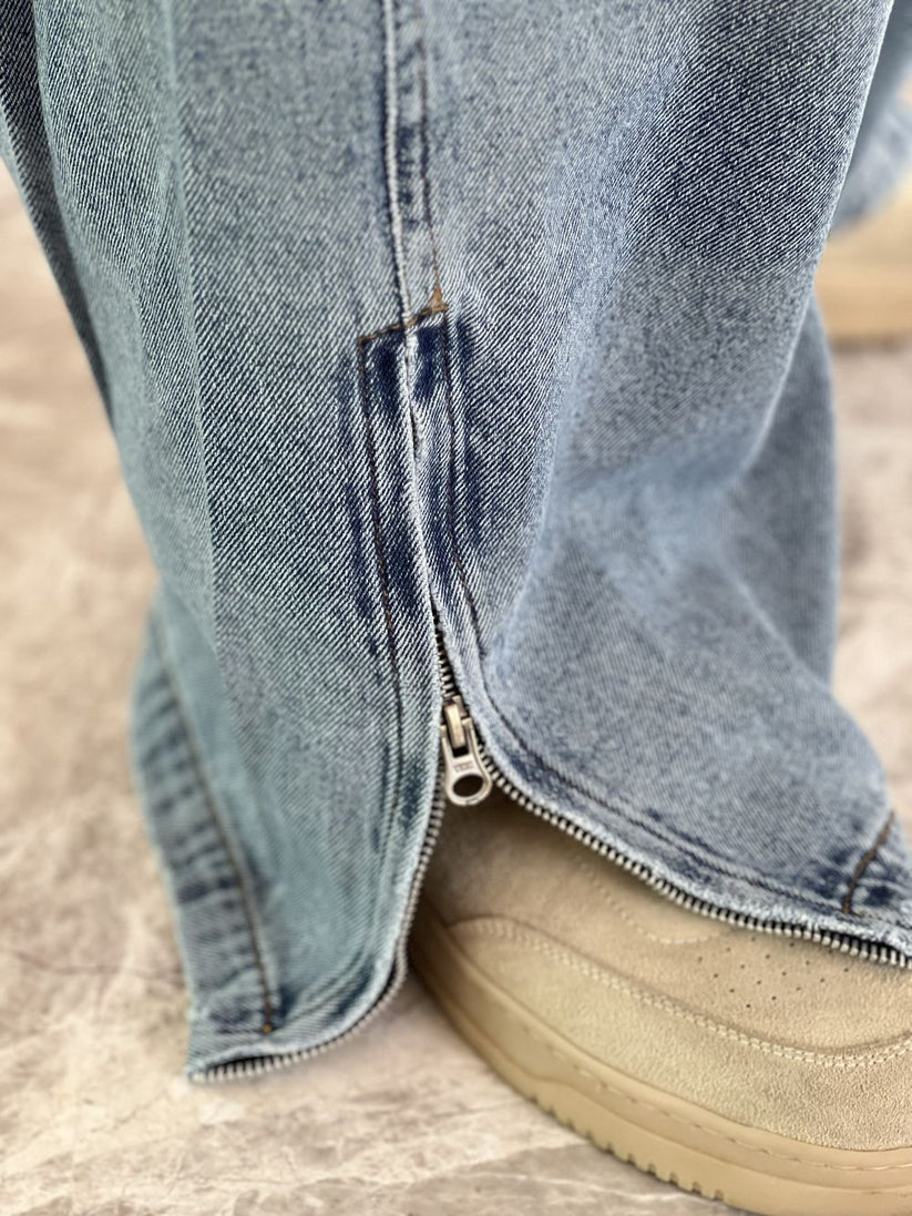 Person wearing light blue baggy jeans with White Boxy Tshirt by 1947 clothing.