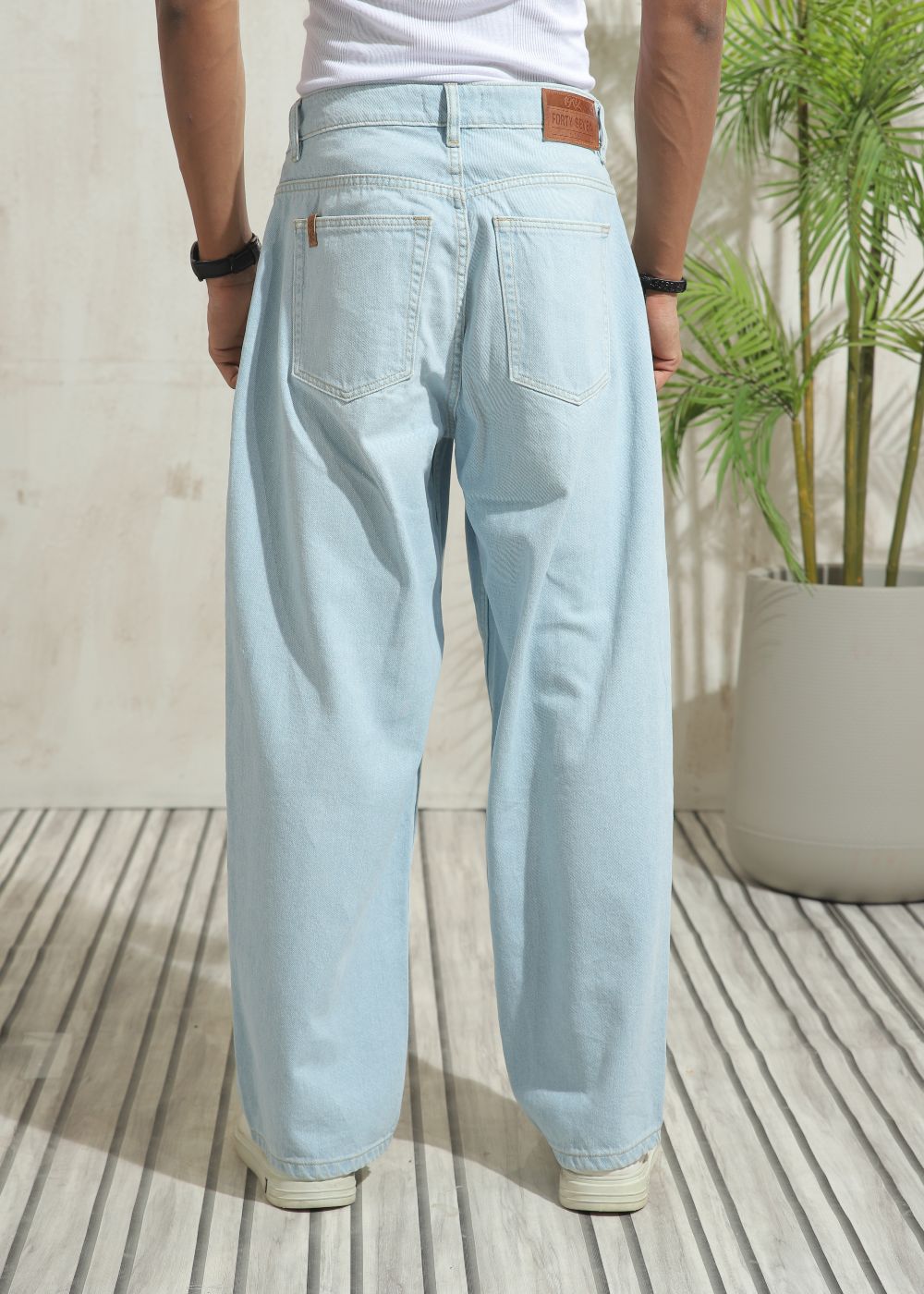 Men’s loose fit light wash blue wide leg jeans with clean finish