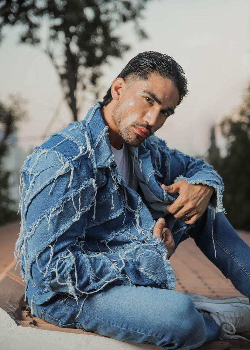Men's light blue distressed denim jacket with frayed detailing
