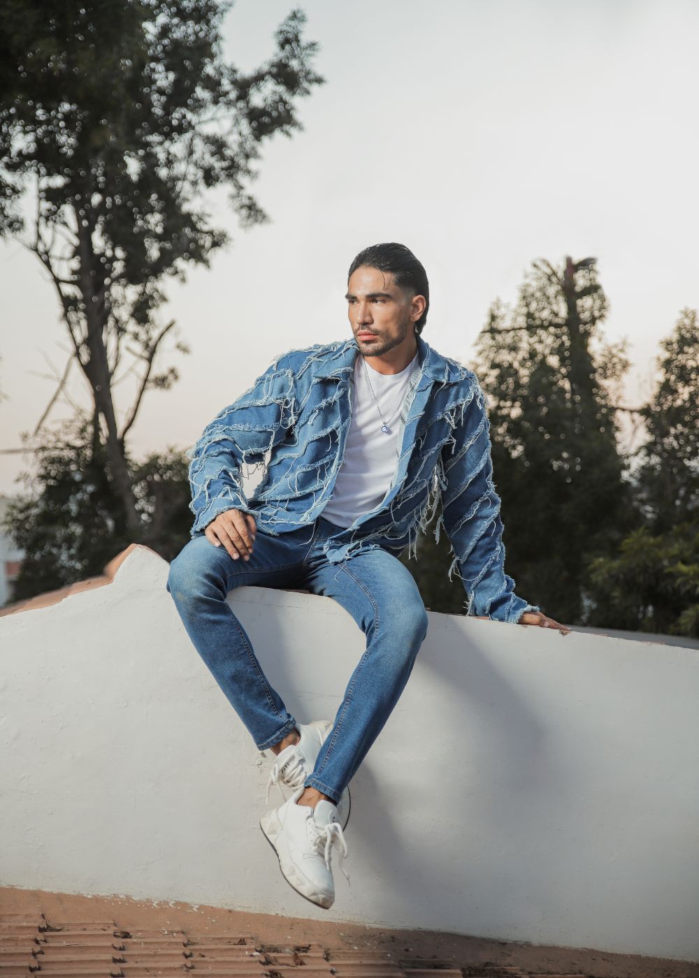 Men's light blue distressed denim jacket with frayed detailing