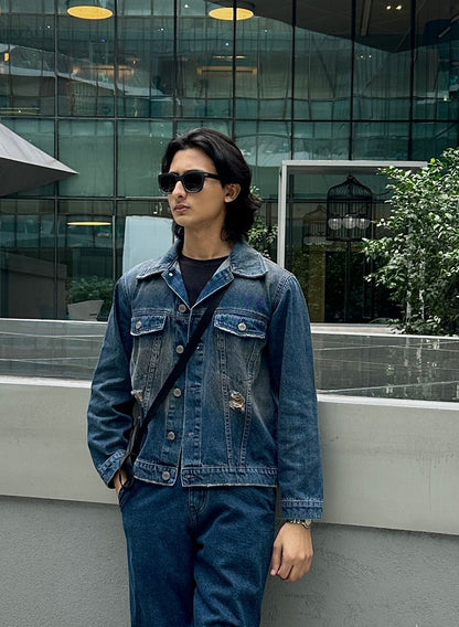 Men's rustic blue distressed denim jacket with ripped detailing