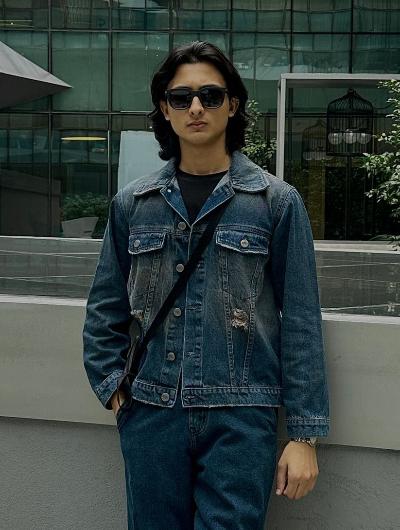Men's rustic blue distressed denim jacket with ripped detailing