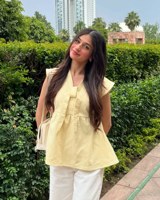 Ladies Peplum Top in Pastel Yellow Featuring a Charming Bow Tie in the Front