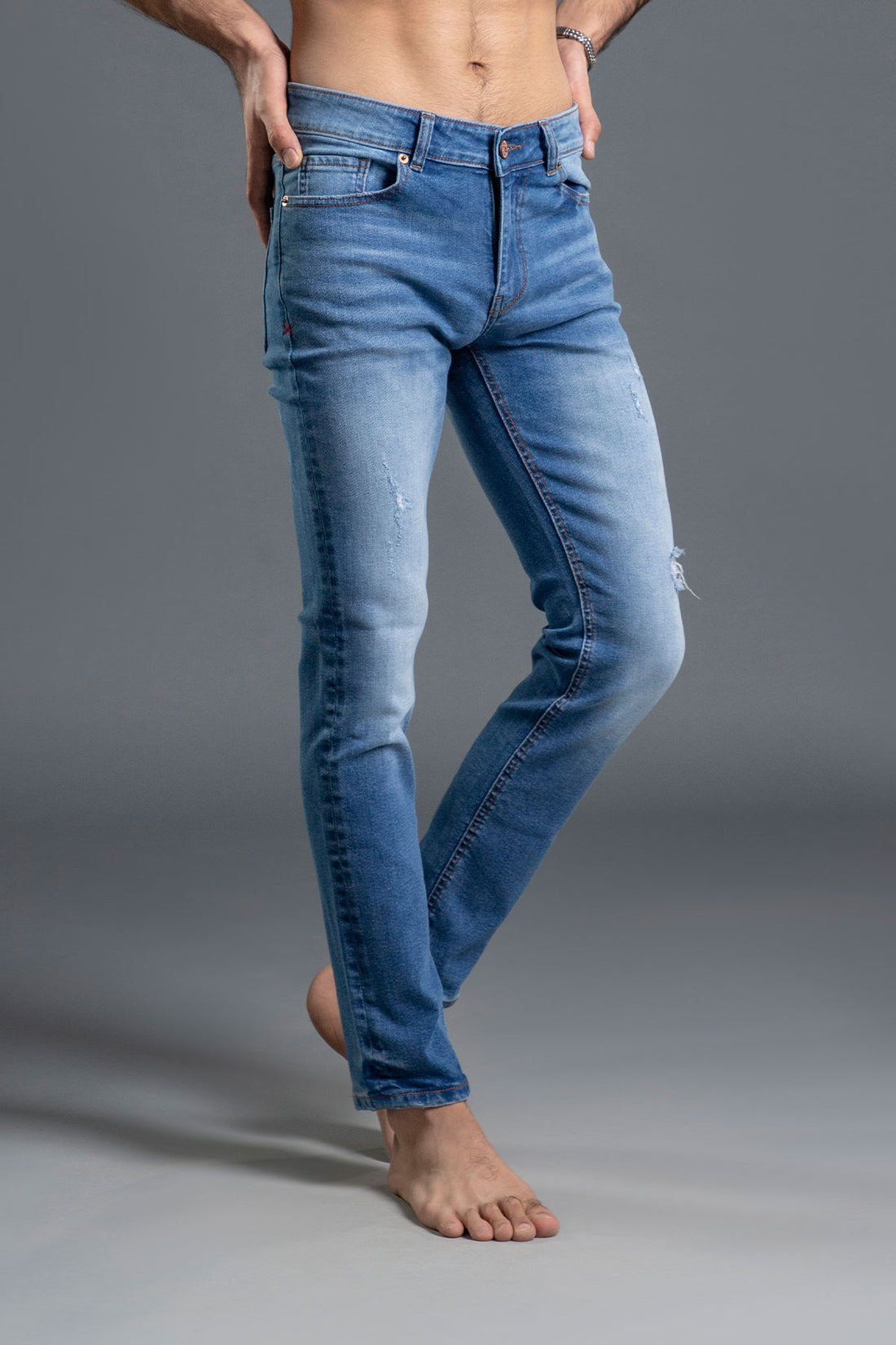 Men's light blue ripped and repaired skinny jeans