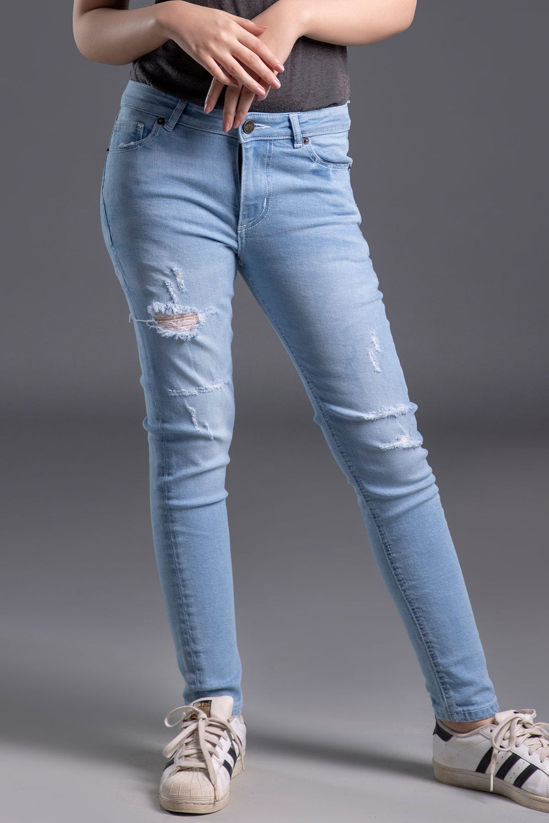 Women's Skinny Ripped Jeans in Light Blue Wash Featuring a Zipper Fly and Handmade Ripped and Repaired Abrasions