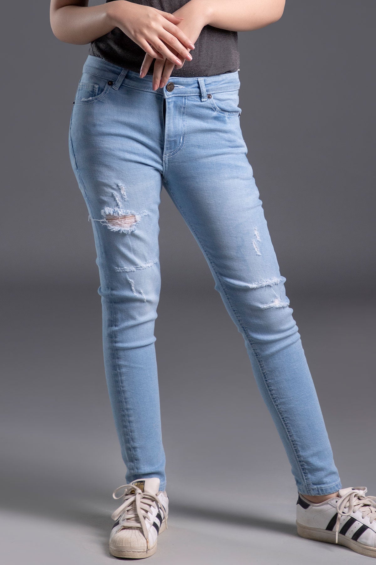 Women's Skinny Ripped Jeans in Light Blue Wash Featuring a Zipper Fly and Handmade Ripped and Repaired Abrasions